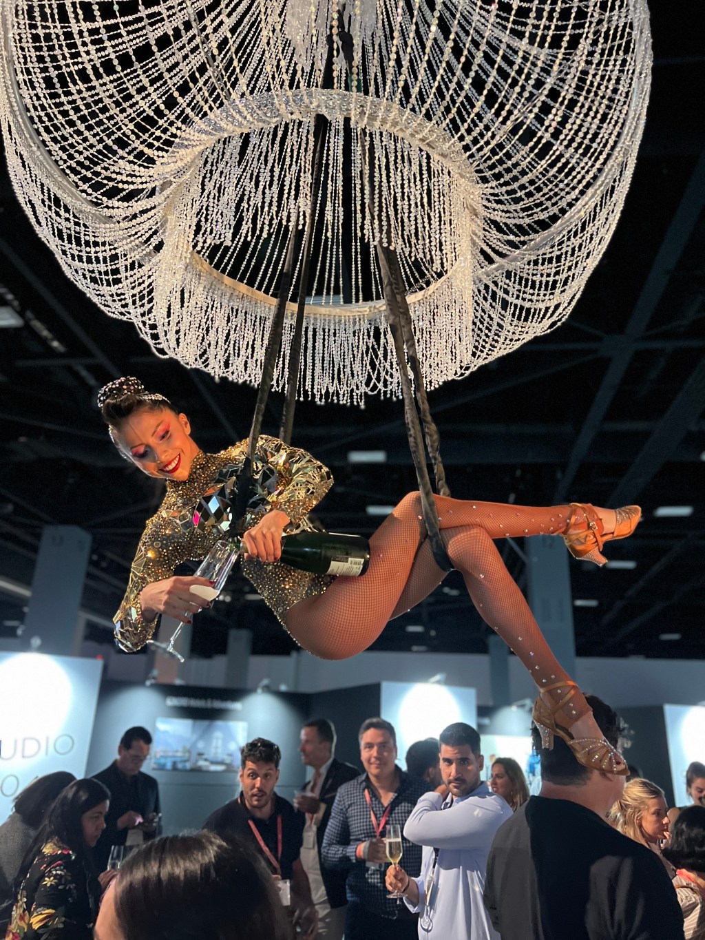 Aerial champagne server pouring drinks while suspended above guests at a luxury event